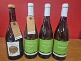 quatre bouteilles de vin sont alignées sur une table en bois