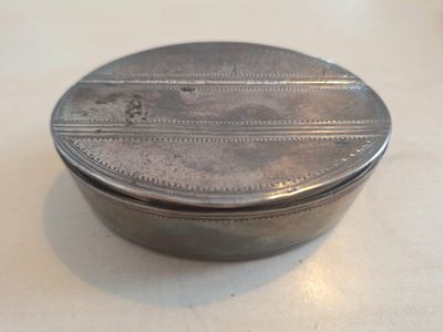 une petite boîte en argent posée sur une table