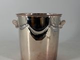a silver ice bucket with a handle on a table