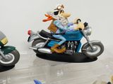 two figurines of a man riding a motorcycle and a dog riding a motorcycle