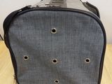 a gray bag with holes on it sitting on a table