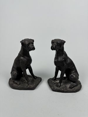 deux figurines de chiens noirs assis l'une sur l'autre