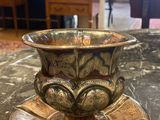 une tasse et une soucoupe en or posées sur une table en marbre