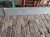 a metal rail that is sitting on a brick floor