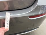a hand that is holding a measuring tape near a car