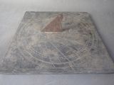 an old sundial on a table with a gray background
