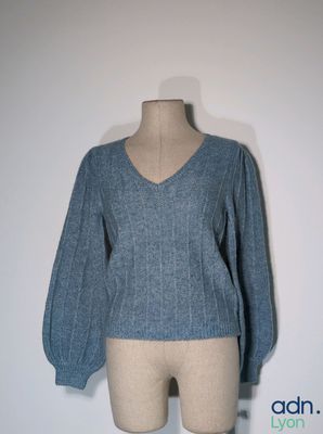 the top of a mannequin torso with a blue sweater on it