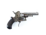un vieux pistolet est posé sur une surface blanche, devant un fond blanc