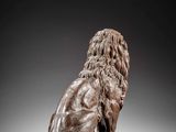 a bronze statue of a lion sitting on top of a wooden base