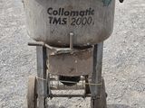 a cement mixer sitting in the middle of a gravel lot