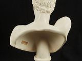 white marble bust of a man with a hat on top of it