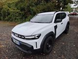 Le SUV blanc est garé sur le gravier du parking.
