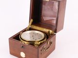 an old wooden box with a compass inside of it on a white surface