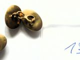 une photo d'une paire de boucles d'oreilles en or posées sur une surface blanche