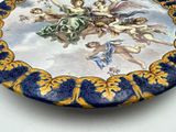 a blue and yellow plate with a painting of angels on it