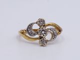 a close up of a gold and diamond ring on a white surface