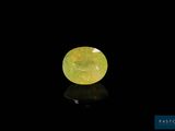 une pierre de jade jaune de forme ovale sur fond noir