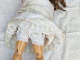 two dolls that are laying next to each other on a bed