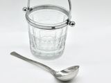 a silver spoon and a glass on a white table
