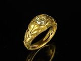 gros plan d'une bague en or avec un diamant au centre