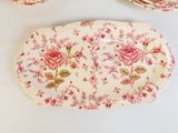 une table blanche sur laquelle sont disposées des assiettes ornées de fleurs roses