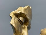 une statue en or représentant un homme et une femme les yeux fermés