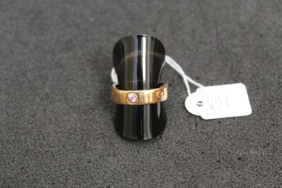 a ring with a pink stone in it on a table