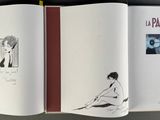 an open book with a drawing of a woman sitting on the floor