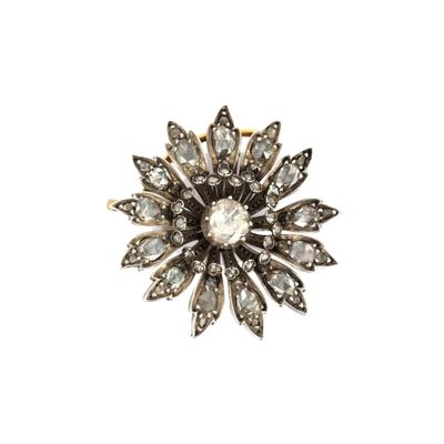 un gros plan d'une broche en forme de fleur en diamant sur fond blanc