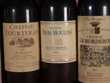 several bottles of red wine are lined up on a shelf