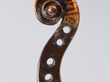 a close up of the back of a violin with a fiddle in the foreground