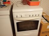 a white stove top oven sitting next to a washing machine