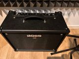 the boss amp is sitting on the floor in front of a chair