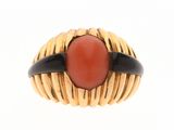 une image d'une bague en or avec une pierre rouge au centre