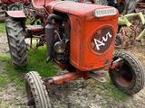 un tracteur rouge qui est garé dans la terre