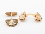 a pair of gold cufflinks with a fan design