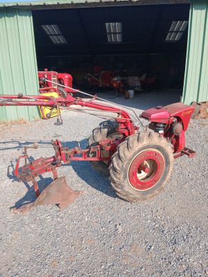 a red tractor that is parked in front of a building