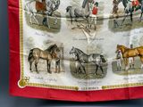 une image représentant une écharpe rouge ornée de chevaux et de jockeys