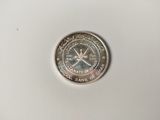 a silver coin on a white surface with a white background