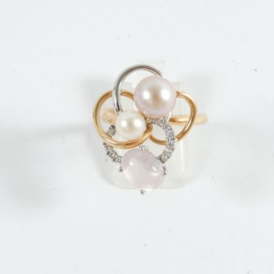 a ring with pearls and diamonds on it on a white surface