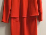 une robe rouge accrochée au mur près d'une porte