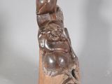 a small statue of a man sitting on top of a rock
