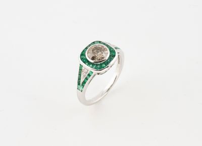 a close up of a ring with a green stone in the center