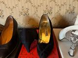 several pairs of women ' s shoes sitting on top of boxes in front of a wallpapered wall