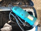 une perceuse électrique bleue dans un coffret posé par terre