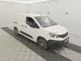 La camionnette blanche est garée dans le garage, sur le sol à damier.
