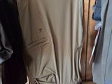 many jackets and pants hanging on a rack in a store