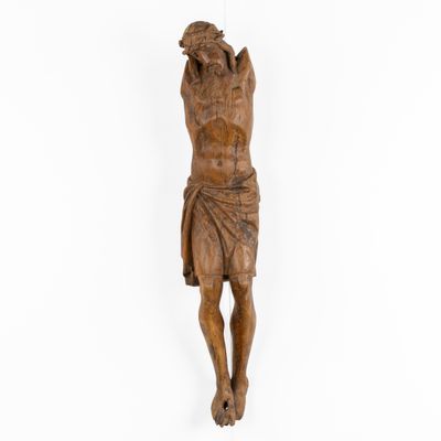 a wooden statue of jesus hanging on a white wall