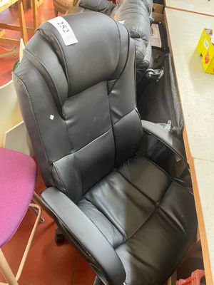 une chaise de bureau noire placée au milieu d'une pièce