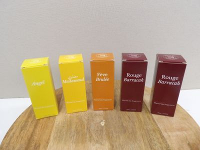 four boxes of perfume sitting on top of a wooden table